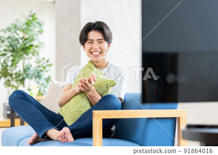 Young man watching tv in the living room 91864016