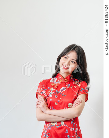 穿著傳統旗袍的美麗亞洲年輕女人站在白色背景前 91865424