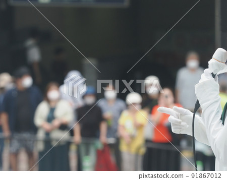 Audience wearing a mask and listening to candidates giving street speeches in the campaign 91867012