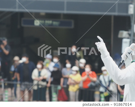 Audience wearing a mask and listening to candidates giving street speeches in the campaign 91867014