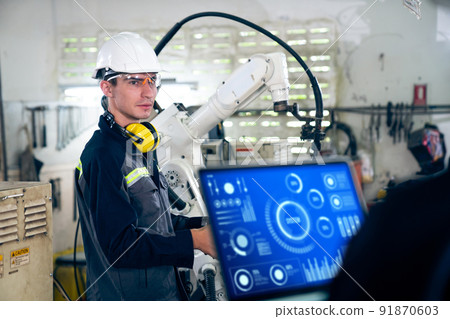 Factory workers working with adept robotic arm in a workshop 91870603