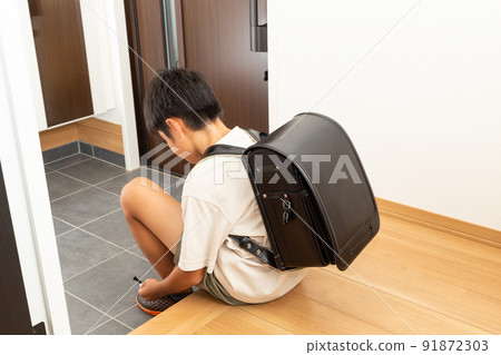 Elementary school students wearing shoes at the entrance 91872303