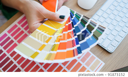 Interior designer holding fan of colourful samples in hand Interior designer holding fan of colourful samples in hand 91873152