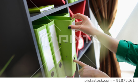 Female hands taking off green folder with documents Female hands taking off green folder with documents 91873161