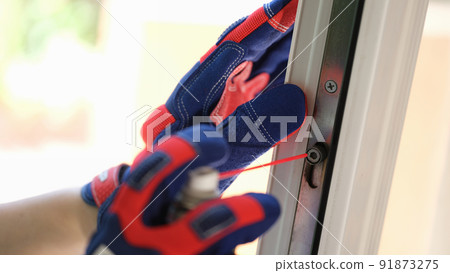Repairman using lubricate for fix up problem with lock of plastic window. Repairman using lubricate for fix up problem with lock of plastic window. 91873275