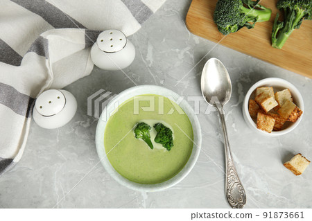 Delicious broccoli cream soup served on grey marble table, flat lay 91873661