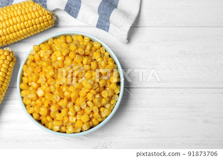 Delicious canned corn in bowl on white wooden table, flat lay. Space for text Delicious canned corn in bowl on white wooden table, flat lay. Space for text 91873706
