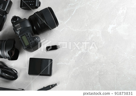 Flat lay composition with equipment for professional photographer on grey marble table. Space for text 91873831