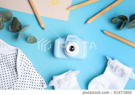 Flat lay composition with toy camera on light blue background. Future photographer 91873860