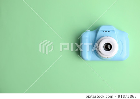 Light blue toy camera on light green background, top view with space for text. . Future photographer Light blue toy camera on light green background, top view with space for text. . Future photographer 91873865