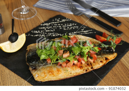 Delicious grilled fish served on wooden table 91874032