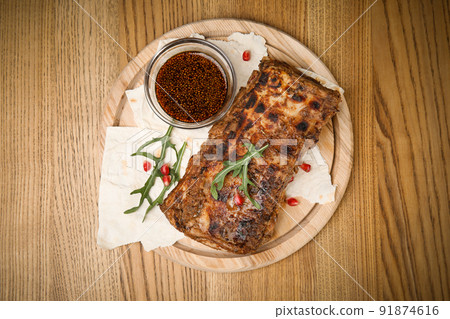 Delicious grilled ribs served on wooden table, top view 91874616