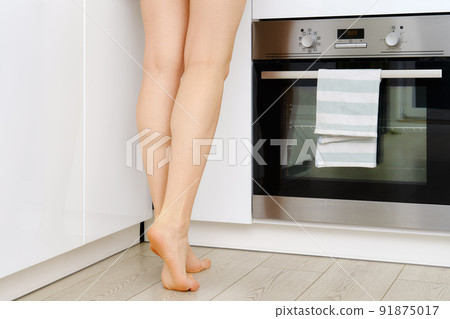 Rear view at female legs in the kitchen 91875017