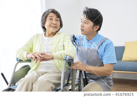 坐在輪椅上的老年婦女和中年男子的護理人員 坐在輪椅上的老年婦女和中年男子的護理人員 91876925
