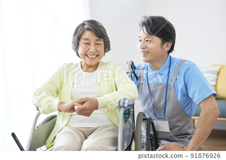 坐在輪椅上的老年婦女和中年男子的護理人員 坐在輪椅上的老年婦女和中年男子的護理人員 91876926