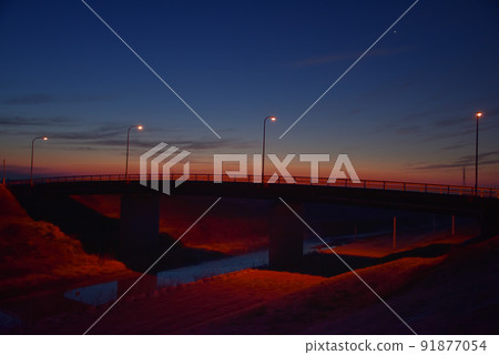 日出和橙色路燈照亮的橋樑 日出和橙色路燈照亮的橋樑 91877054