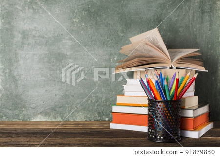 Stack of books and stationery on the background of the school board. Stack of books and stationery on the background of the school board. 91879830