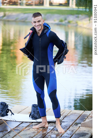 Portait of wakeboarder making ready of surfing on lake. Happy surfer wearing wetsuit of wakeboarding in the cable park. Water sport, outdoor activity concept. 91880941