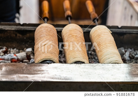 trdelnik dessert baked goods of europe is cooked on fire in the shape of a cone close-up 91881678
