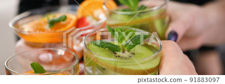 People holding cooling drinks cocktails and make clink with glasses, cheers or toast 91883097