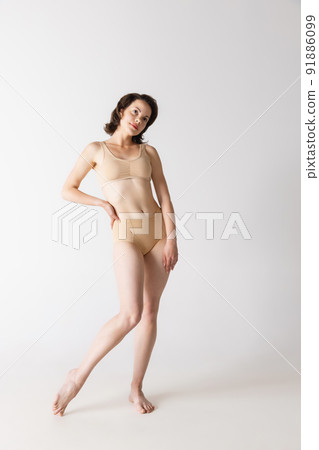 Portrait of young beautiful slim girl in underwear posing isolated over gray studio background. Wellness, wellbeing, fitness, fashion concept. Portrait of young beautiful slim girl in underwear posing isolated over gray studio background. Wellness, wellbeing, fitness, fashion concept. 91886099