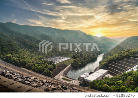 Large Hydro Electricity Dam Power plant with mountain and sunset in background for renewable energy concept. Large Hydro Electricity Dam Power plant with mountain and sunset in background for renewable energy concept. 91886270