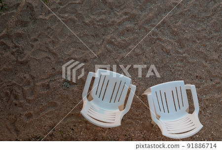 two empty chairs on the sand top view 91886714