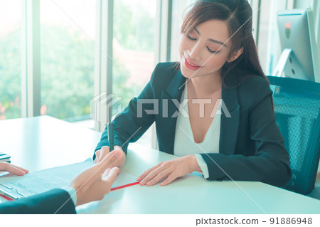 Female job canidate is signing work contract with HR officer after a sucessful job interview. 91886948