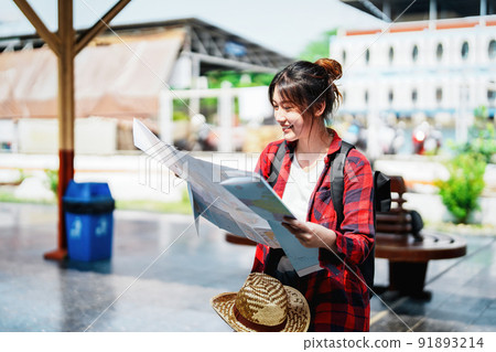 summer, relax, vacation, travel, portrait of a cute Asian girl looking at a map to plan a trip while waiting at the train station summer, relax, vacation, travel, portrait of a cute Asian girl looking at a map to plan a trip while waiting at the train station 91893214