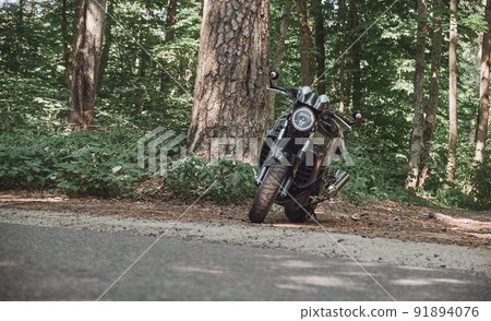 Black road bike on the roadside of a forest road, no people Black road bike on the roadside of a forest road, no people 91894076