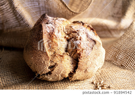 Round bread close-up on white background. Freshly baked sourdough bread with a golden crust. Baker shop context with delicious bread. Round bread close-up on white background. Freshly baked sourdough bread with a golden crust. Baker shop context with delicious bread. 91894542