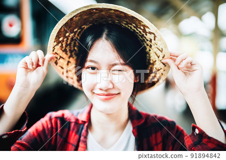 summer, relax, vacation, travel, portrait of cute Asian girl showing smile and showing joy while waiting at the train station for a summer trip 91894842