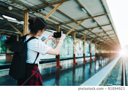 summer, relax, vacation, travel, portrait of beautiful Asian girl using the smartphone mobile take a photo at the train station while waiting for their travel time summer, relax, vacation, travel, portrait of beautiful Asian girl using the smartphone mobile take a photo at the train station while waiting for their travel time 91894921