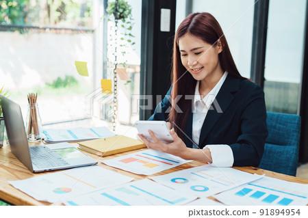financial, Planning, Marketing and Accounting, portrait of Asian woman Economist using calculator to calculate investment documents with partners on profit taking to compete with other companies. financial, Planning, Marketing and Accounting, portrait of Asian woman Economist using calculator to calculate investment documents with partners on profit taking to compete with other companies. 91894954