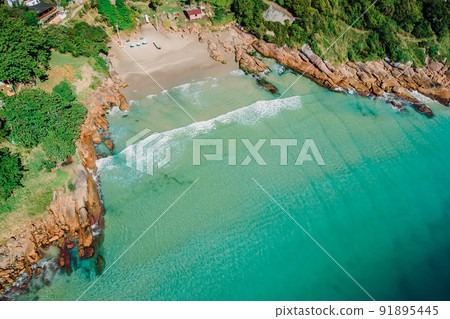 Beach, stones and transparent ocean in Brazil. Aerial view of tropical beach in Florianopolis 91895445