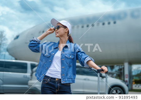 travel business Portrait of an Asian woman showing joy while waiting for a flight. 91895493