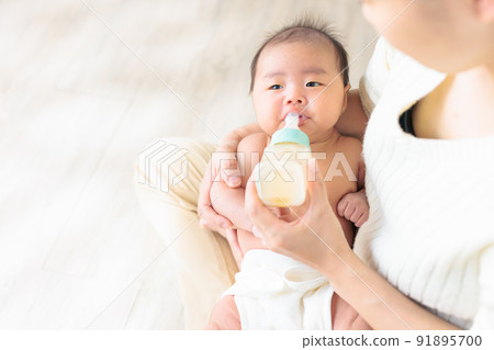 Baby drinking milk, play drinking, uneven drinking, leftovers, distracting copy space Baby drinking milk, play drinking, uneven drinking, leftovers, distracting copy space 91895700