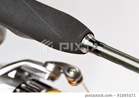 Spinning reel with fishing line on a white background. 91895871