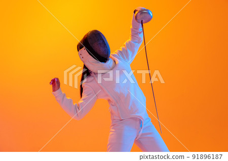 Studio shot of professional fencer in white fencing costume and mask in action, motion isolated on orange color background. Sport, youth, activity, skills, Studio shot of professional fencer in white fencing costume and mask in action, motion isolated on orange color background. Sport, youth, activity, skills, 91896187