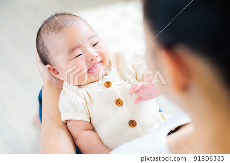 媽媽腿上的接觸,一個微笑的 2 個月大的嬰兒 媽媽腿上的接觸,一個微笑的 2 個月大的嬰兒 91896383