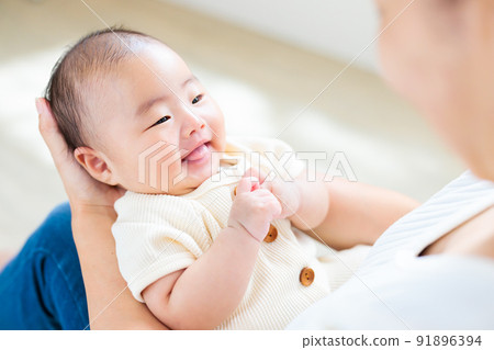 Contact on mom's lap, a smiling baby 2 months old 91896394
