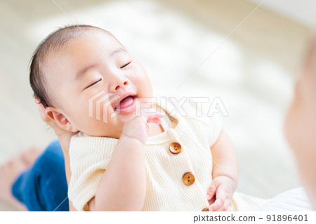 媽媽腿上的接觸,一個微笑的 2 個月大的嬰兒 媽媽腿上的接觸,一個微笑的 2 個月大的嬰兒 91896401
