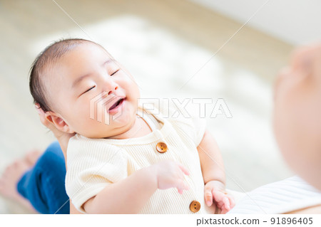 媽媽腿上的接觸，一個微笑的 2 個月大的嬰兒 91896405