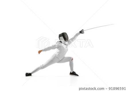 Young girl, beginner fencer in fencing costume and mask practicing with rapier isolated on white background. Sport, youth, healthy lifestyle, achievements. 91896591