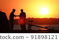 Silhouette of fishermen on the pier at sunset 91898121