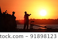 Silhouette of fishermen on the pier at sunset 91898123