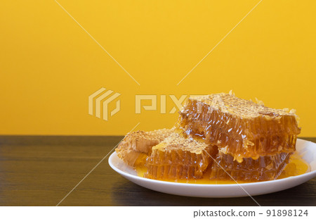 Honeycombs in white plate on the wooden table. Natural organic bee product. Healthy lifestyle. Copy space for your text. Close-up photo. 91898124