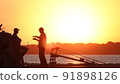Silhouette of fishermen on the pier at sunset 91898126