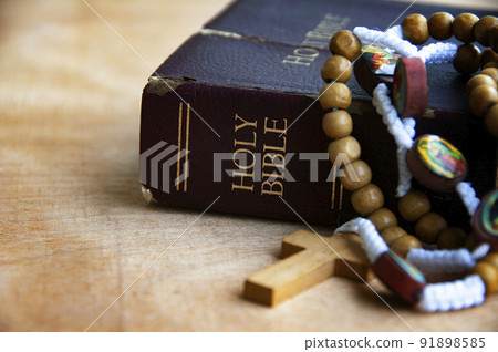 Holy Bible and Rosary on a wooden table with customizable space to add ideas or text. Christianity concept. 91898585