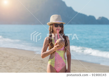 Portrait of a cute girl with a coconut on a Turkish beach. 91900143